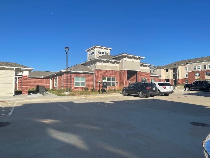 Pecan Creek apartment building exterior in Aubrey, TX showing main entrance