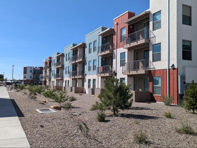 Encanto at Mesa del Sol building exterior with covered parking and walkway in Albuquerque, NM