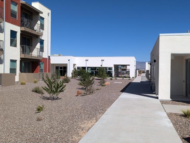 Swimming pool area at Encanto at Mesa del Sol with lounge chairs and umbrellas